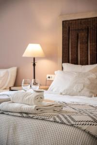 a bed with two wine glasses and towels on it at Vranas Ambiance Hotel in Chania Town