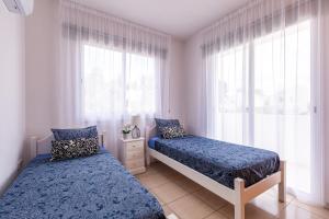 Un dormitorio con dos camas y una ventana. en Just renovated beautiful 2 bed apartment in Paphos 5 min drive to the beach, en Pafos 35 fotos más