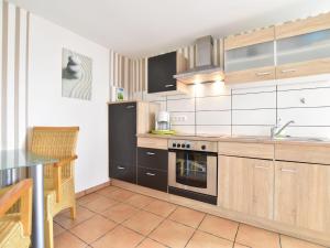 a kitchen with wooden cabinets and a stove top oven at Boutique Bungalow in Insel Poel with terrace in Insel Poel
