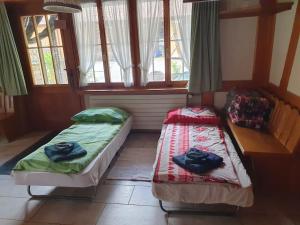 2 Betten in einem Zimmer mit Fenstern in der Unterkunft Aufschnaufhof in Diemtigen