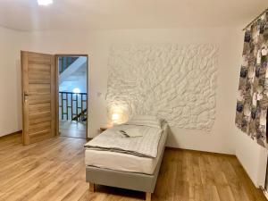 a bedroom with a bed and a large painting on the wall at Folwark Sudecki in Marciszów