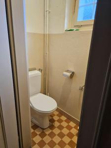 a bathroom with a white toilet and a checkered floor at Aufschnaufhof in Diemtigen