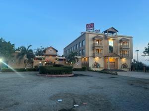 贾姆讷格尔Rajwadu The Village的一家前面有停车场的酒店