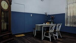 a dining room with a table and a clock at Kalia Cottage in Batu +7 photos