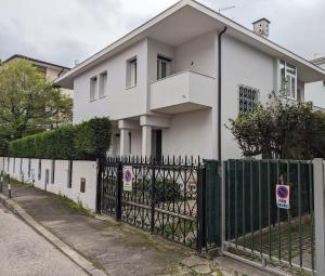ein weißes Haus mit einem Zaun davor in der Unterkunft Spazioso Appartamento in casa singola Padova con giardino in Padua