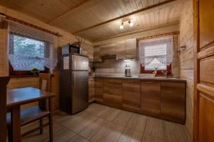 a kitchen with a refrigerator and a table in a cabin at Drevenička Vodníček in Liptovský Trnovec
