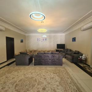 Il comprend un grand salon avec un canapé et une télévision. dans l'établissement سكن مريح, à Dubaï