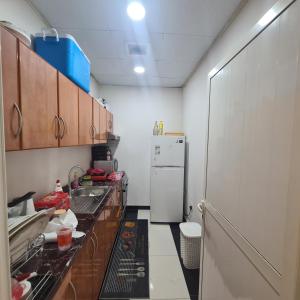 La cuisine est équipée d'un évier et d'un réfrigérateur. dans l'établissement سكن مريح, à Dubaï