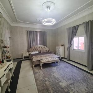 1 dormitorio con cama y lámpara de araña en سكن مريح, en Dubái