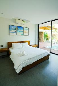 um quarto com uma cama grande com duas toalhas em Kiwuki Beachfront Villa em Phu Quoc