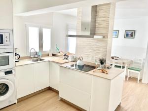 cocina blanca con fregadero y lavavajillas en Apartamento Zarracina Centro, en Gijón