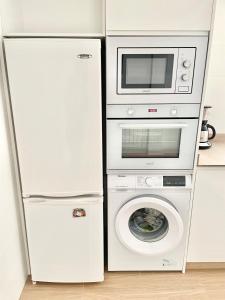 Un réfrigérateur est disponible à côté d'un lave-linge et d'un four micro-ondes. dans l'établissement Apartamento Zarracina Centro, à Gijón