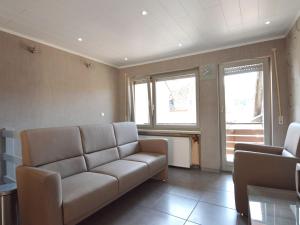 un soggiorno con divano e 2 finestre di Attractive Apartment in Zell near River a Zell an der Mosel