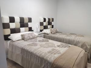 a room with two beds and a table at Apartamento Confort II in La Seu d'Urgell