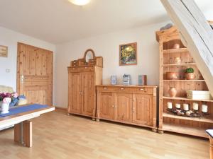 a living room with wooden cabinets and a bench at Elegant Holiday Home in Kr pelin near Horse Riding in Boldenshagen