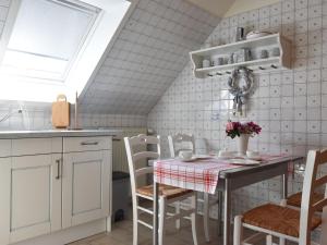 eine Küche mit einem Tisch und Stühlen sowie einem Fenster in der Unterkunft Elegant Holiday Home in Kr pelin near Horse Riding in Boldenshagen