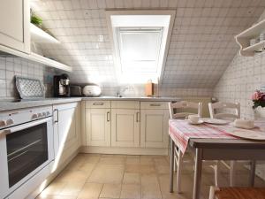 a kitchen with white cabinets and a table and a window at Elegant Holiday Home in Kr pelin near Horse Riding in Boldenshagen