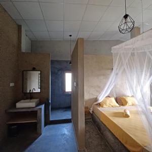 um quarto com uma cama, um lavatório e um espelho em The Traveller Kandy em Kandy