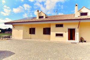 a small white house with a brick driveway at Casa Ballestri - Vallelunga, Lago & Natura in Campagnano di Roma