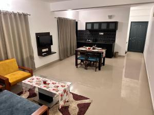 een woonkamer met een tafel en een televisie bij SKY VIEW RESORTS in Munnar