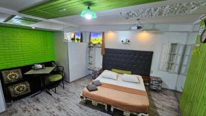 ein Schlafzimmer mit einem Bett und einer grünen Wand in der Unterkunft Mamba Hotel in Dnipro