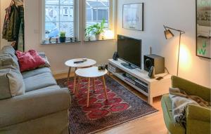 ein Wohnzimmer mit einem Sofa, einem Tisch und einem TV in der Unterkunft 2 Bedroom Amazing Home In Mrbylnga in Mörbylånga
