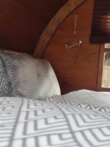 レバークーゼンにあるFür Alleinreisende-1 Person- Single Room- Rustikales freistehendes Mini Holzfass zum Schlafen, mit angrenzendem Badezimmer!の木製の壁にハートサイン付きのベッド