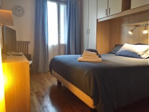 una camera da letto con un letto e due asciugamani di La casetta di Elena - Sondrio Valtellina a Sondrio