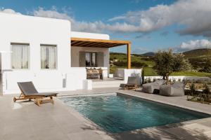 a villa with a swimming pool in front of a house at P square Luxury villas Naxos in Kastraki