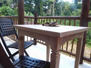 una mesa de madera y 2 sillas en el porche en Vila Engawa Flats, en Itacaré