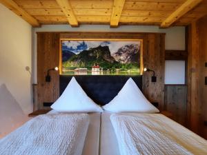 シェーナウ・アム・ケーニッヒスゼーにあるAppartements Hochödlehenの壁に絵画が飾られた部屋のベッド2台