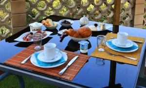 einen Tisch mit Teller mit Speisen darüber in der Unterkunft Maison Les Fraysses in Bellefont-La Rauze