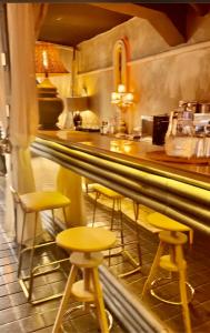 un bar con taburetes amarillos y un mostrador en Natura LifeStyle gran Vía, en Madrid