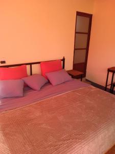 uma cama com almofadas vermelhas e roxas em terraza netzahualcoyotl em Tepoztlán
