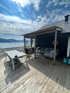 een houten terras met een picknicktafel en een huis bij Hytte på telnes (Sandhornøy) in Finnset