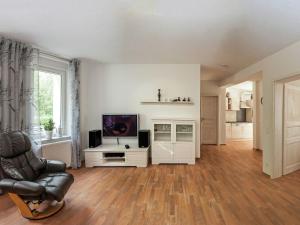 ein Wohnzimmer mit einem Stuhl und einem TV in der Unterkunft Bright apartment in Thale with terrace in Thale