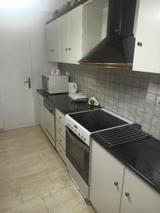 uma cozinha com um fogão e uma bancada em Comfortable apartment 200 m from the sea em Piraeus