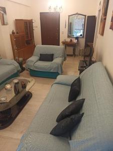 uma sala de estar com dois sofás e uma mesa em Comfortable apartment 200 m from the sea em Piraeus