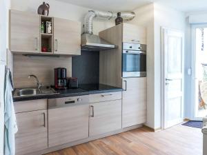 eine Küche mit Holzschränken und einem Waschbecken in der Unterkunft Bright apartment in Thale with terrace in Thale