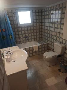 uma casa de banho com um WC, um lavatório e uma banheira em Comfortable apartment 200 m from the sea em Piraeus