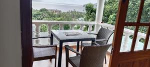 a porch with a table and chairs on a balcony at Tandif Villa Sea View in Takamaka