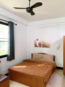 1 dormitorio con 1 cama y ventilador de techo en Tokyo Hotel, en Nakhon Ratchasima