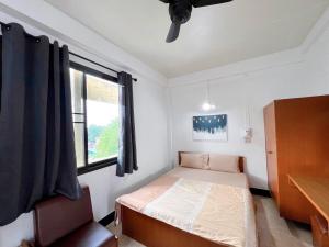 a small bedroom with a bed and a window at Tokyo Hotel in Nakhon Ratchasima