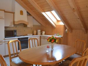 eine Küche mit einem Holztisch mit einer Blumenvase darauf in der Unterkunft Holiday home with panoramic view and every convenience spa in Waldkirchen