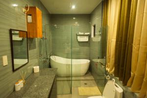 a bathroom with a tub and a toilet and a sink at Raim Hotel in Pagadian