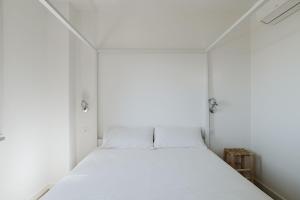 a white bed in a small room with white walls at ABC affittacamere in Celle Ligure