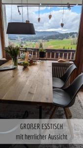 a dining room table with a view of the countryside at Ferienwohnung Bergzeit mit Pool und Sauna in Missen-Wilhams