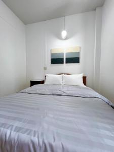 Un dormitorio blanco con una cama grande. en Tokyo Hotel, en Nakhon Ratchasima