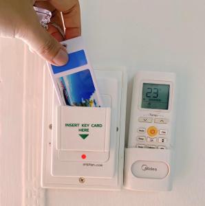 a person holding a nxt key card next to an electronic scale at Tokyo Hotel in Nakhon Ratchasima