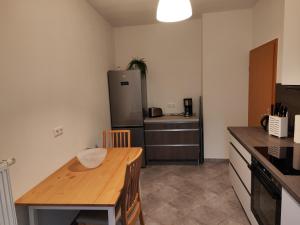 a kitchen with a wooden table and a refrigerator at FeWo Bismarck 29 in Stendal